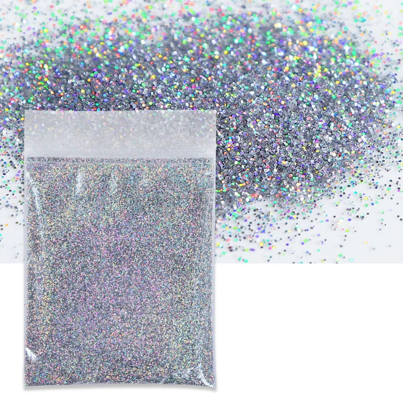 A clear bag filled with holographic fine glitter powder next to a loose pile of iridescent glitter.