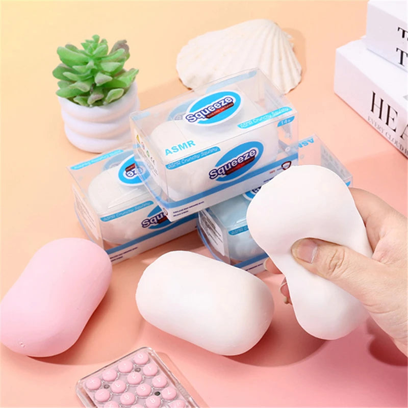 A collection of squishy fidget blocks in various colors and shapes, including a pink block and white silicone pieces.