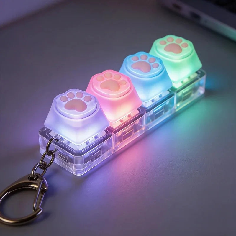 A clear plastic keychain fidget toy shaped like a paw print with glowing LED lights in pastel colors.