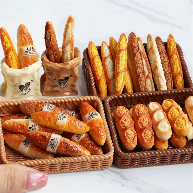 A set of miniature dollhouse baguette baskets filled with small bread loaves and a UFA logo.
