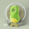 A soft, green baby head protector pillow with adjustable straps is displayed against a light green background.