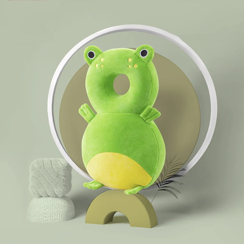 A soft, green baby head protector pillow with adjustable straps is displayed against a light green background.