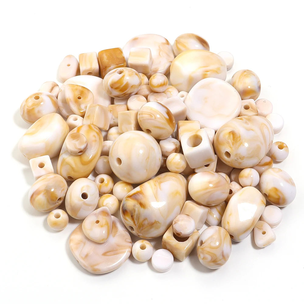 A pile of colorful, translucent acrylic beads in various shapes and shades for jewelry making.