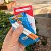 A hand holds a blue package of novelty cigarettes next to a red card labeled Filter Cigarettes.