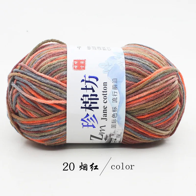 A skein of multi-colored yarn labeled as Zm Jane cotton yarn for knitting and crochet, showing various shades of orange, red,