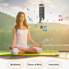 A woman meditating outdoors with a wind chime above her, symbolizing peace of mind and inspiration.