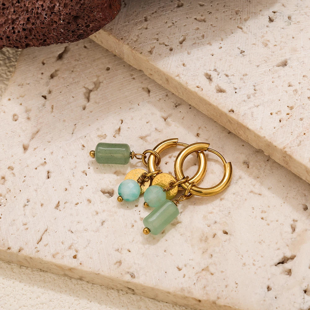 Gold hoop earrings featuring light green and blue-green gemstone beads on a neutral background.