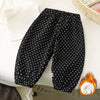 Black fleece-lined polka dot pants laid flat on a white surface.
