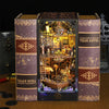 A wooden book nook kit featuring a pirate ship scene, bound in dark brown fabric with gold accents.
