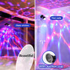 An RGB sound-activated disco ball light illuminating a room with vibrant pink and purple light patterns.