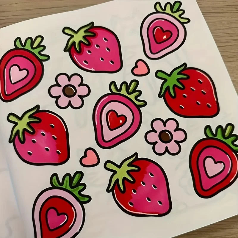 A page from a coloring book featuring various strawberries drawn in bold pink and red outlines with small hearts.