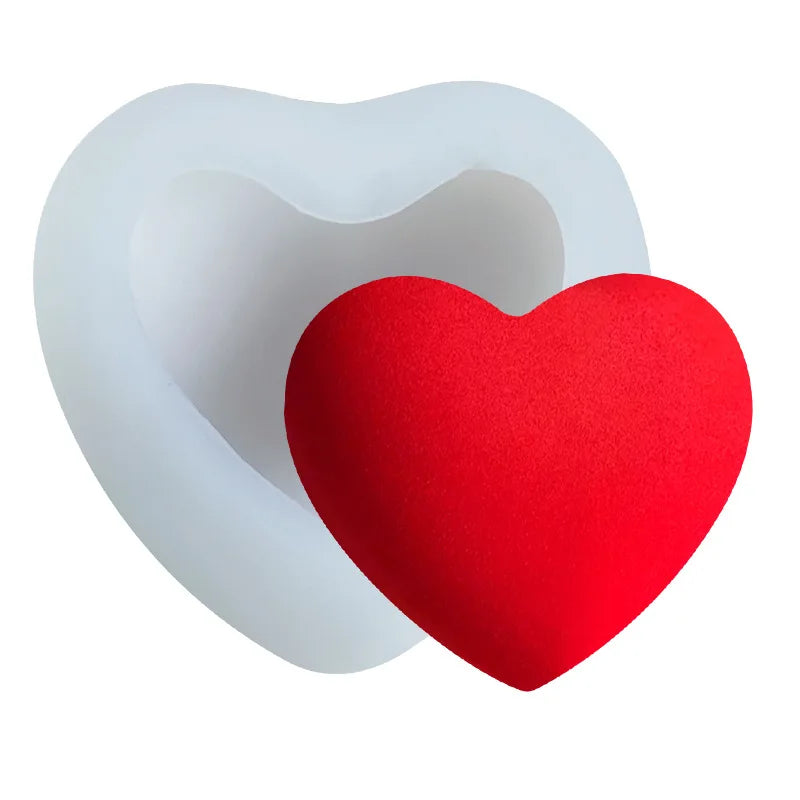 A red heart-shaped silicone mold is placed inside a white, heart-shaped silicone cavity.
