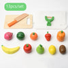 A set of 13 wooden magnetic fruit cutting toys including various fruits and a knife on a white cloth.