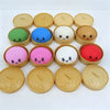A collection of ten pastel-colored mochi squishy fidget toys in various shades of green, blue, white, and pink, arranged in a