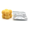 A pile of yellow candle dye chips for soy wax, beeswax, and paraffin.