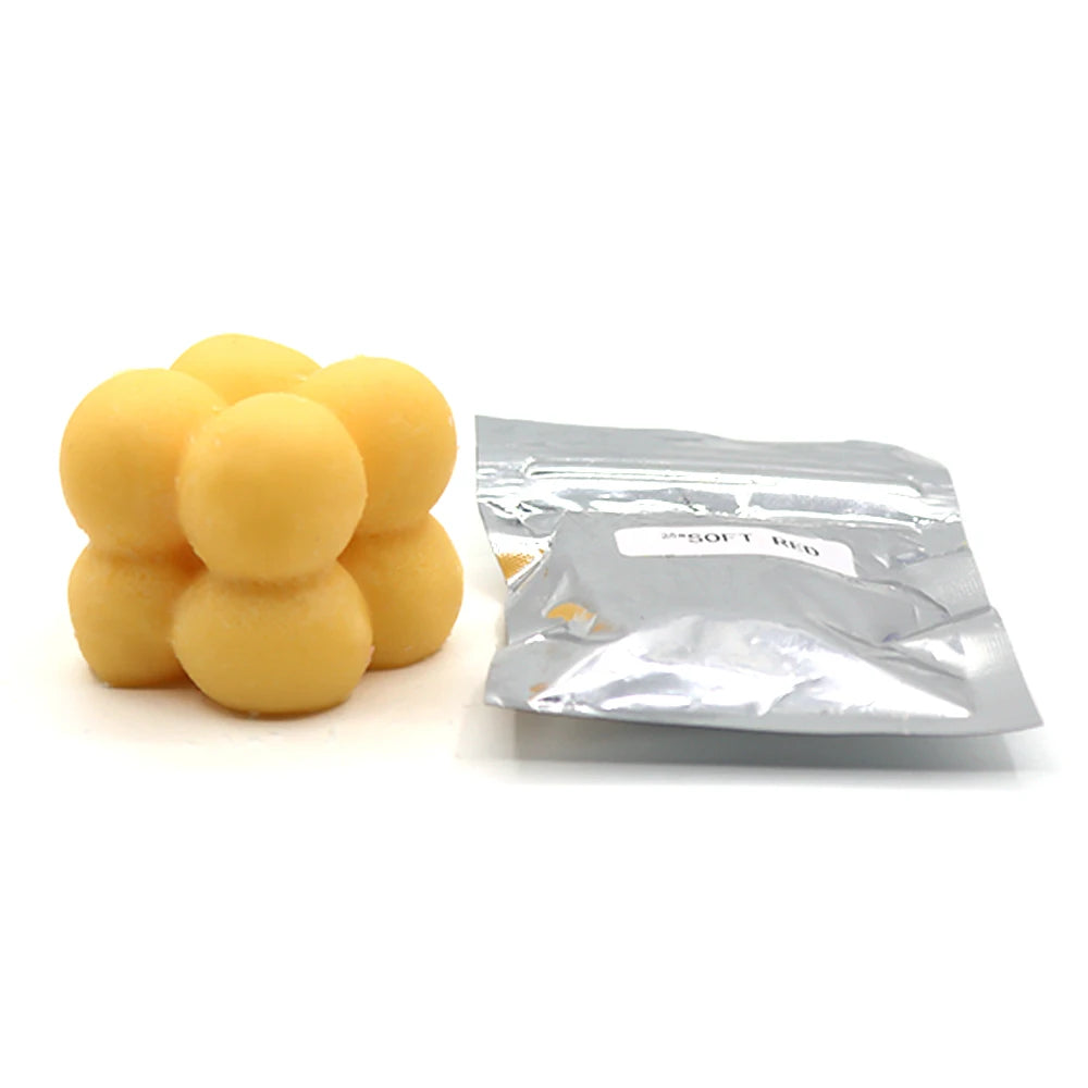 A pile of yellow candle dye chips for soy wax, beeswax, and paraffin.