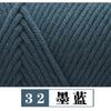 A close-up texture of dark blue yarn knitted in a cable pattern.