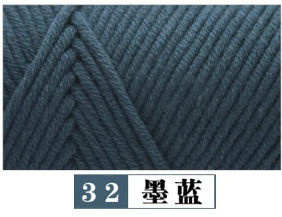 A close-up texture of dark blue yarn knitted in a cable pattern.