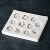 A white silicone mold with various flower shapes, including sunflowers and roses, for chocolate and cake decorating.