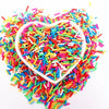 A heart-shaped bowl filled with colorful polymer clay sprinkles for slime and craft decor