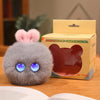 A small, fluffy gray plush rabbit pendant with blue eyes is displayed next to its packaging box.