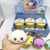 A hand holds a white squishy dumpling fidget toy next to its packaging box.