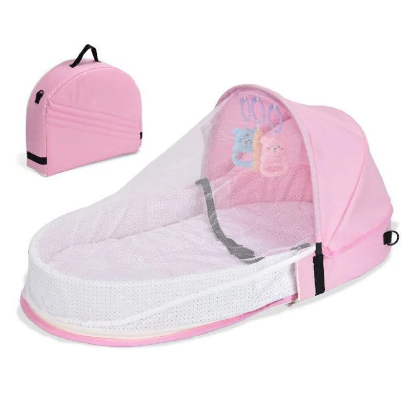 Pink portable foldable baby bed with a mosquito net and mattress shown from above.
