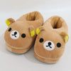 A pair of brown Rilakkuma plush indoor slippers with yellow accents.