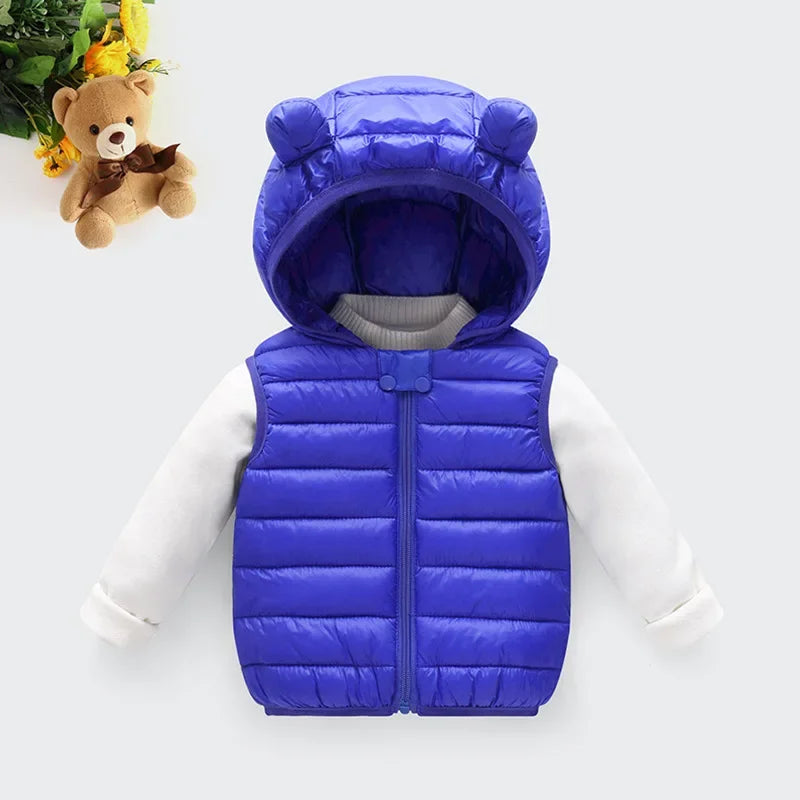 A blue children's hooded vest resembling a bear, worn over a white long-sleeved shirt.