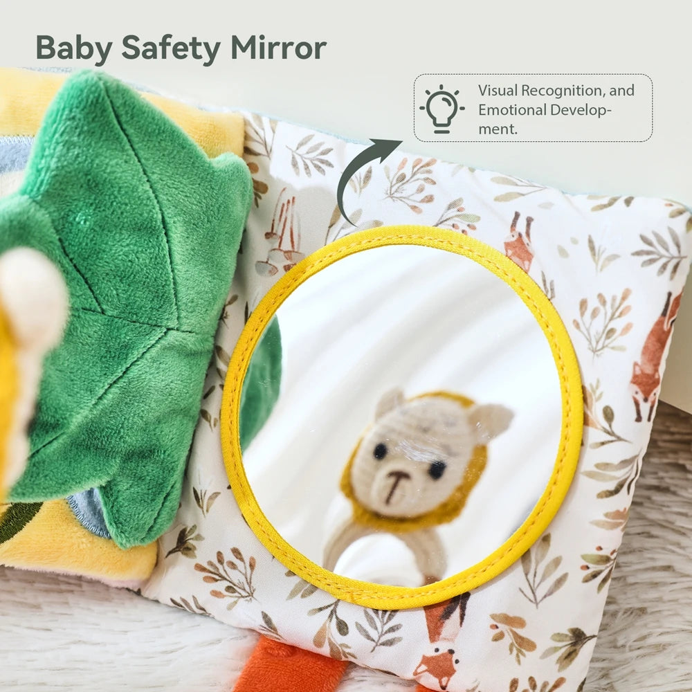 A baby safety mirror with a yellow frame reflecting a small stuffed animal on a patterned fabric background.
