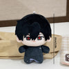 A black plush keychain featuring an anime character with dark hair and red eyes, displayed against a brown paper background.