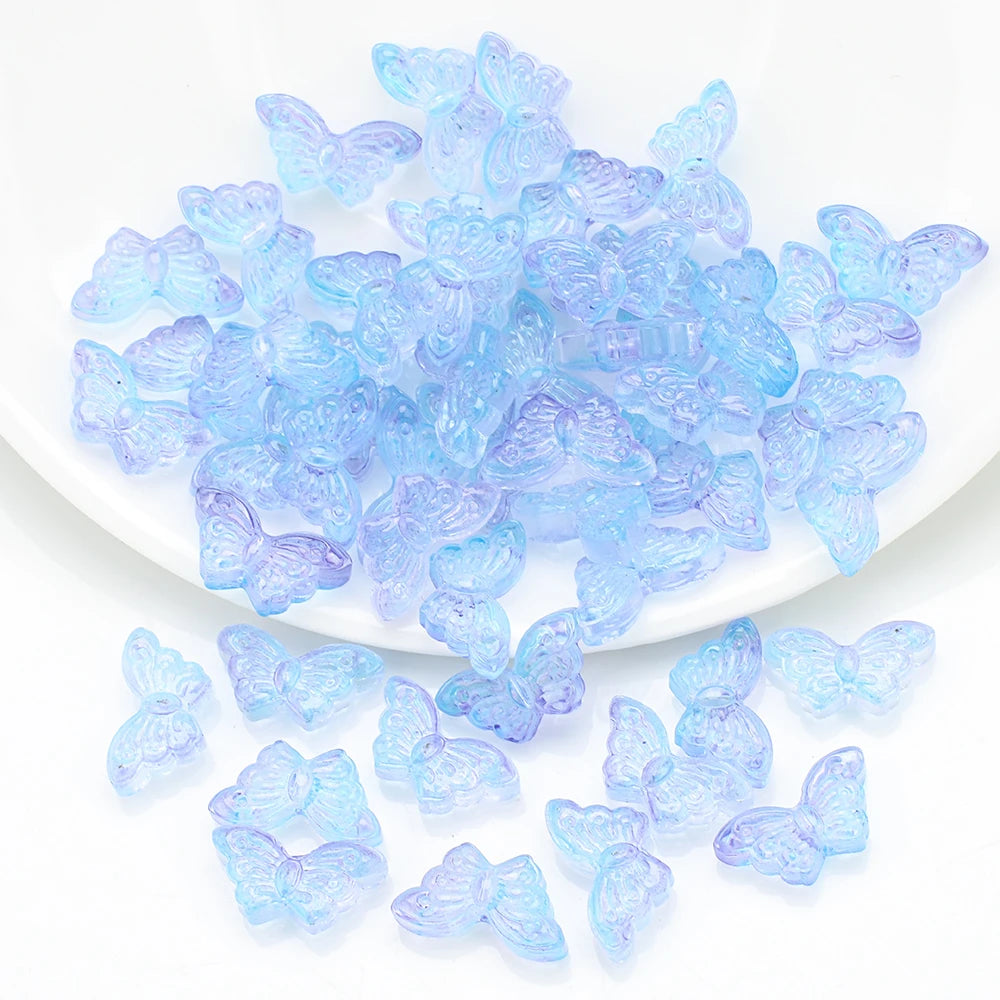 A pile of light blue butterfly glass beads for jewelry making.