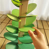 A wooden sensory music tree structure with green leaves and a marble run component.