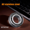 A silver magnetic fidget ring called SPYSTAR is shown on a dark surface next to a laptop keyboard.