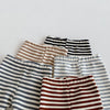 A stack of soft cotton baby leggings featuring various striped designs in beige, brown, and gray tones.