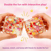 Hands hold two colorful fruit ice cube stress balls demonstrating squeezing and stretching for interactive play