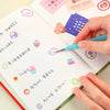Une main utilise un stylo à pointe fine pour dessiner dans un carnet illustré de nourriture mignonne et de texte.