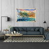 A framed painting depicting a vibrant landscape with birds, animals, and water, displayed above a modern sofa.