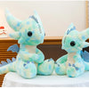 A soft teal and light blue Toothless Dragon plush toy sitting on a white cloth.