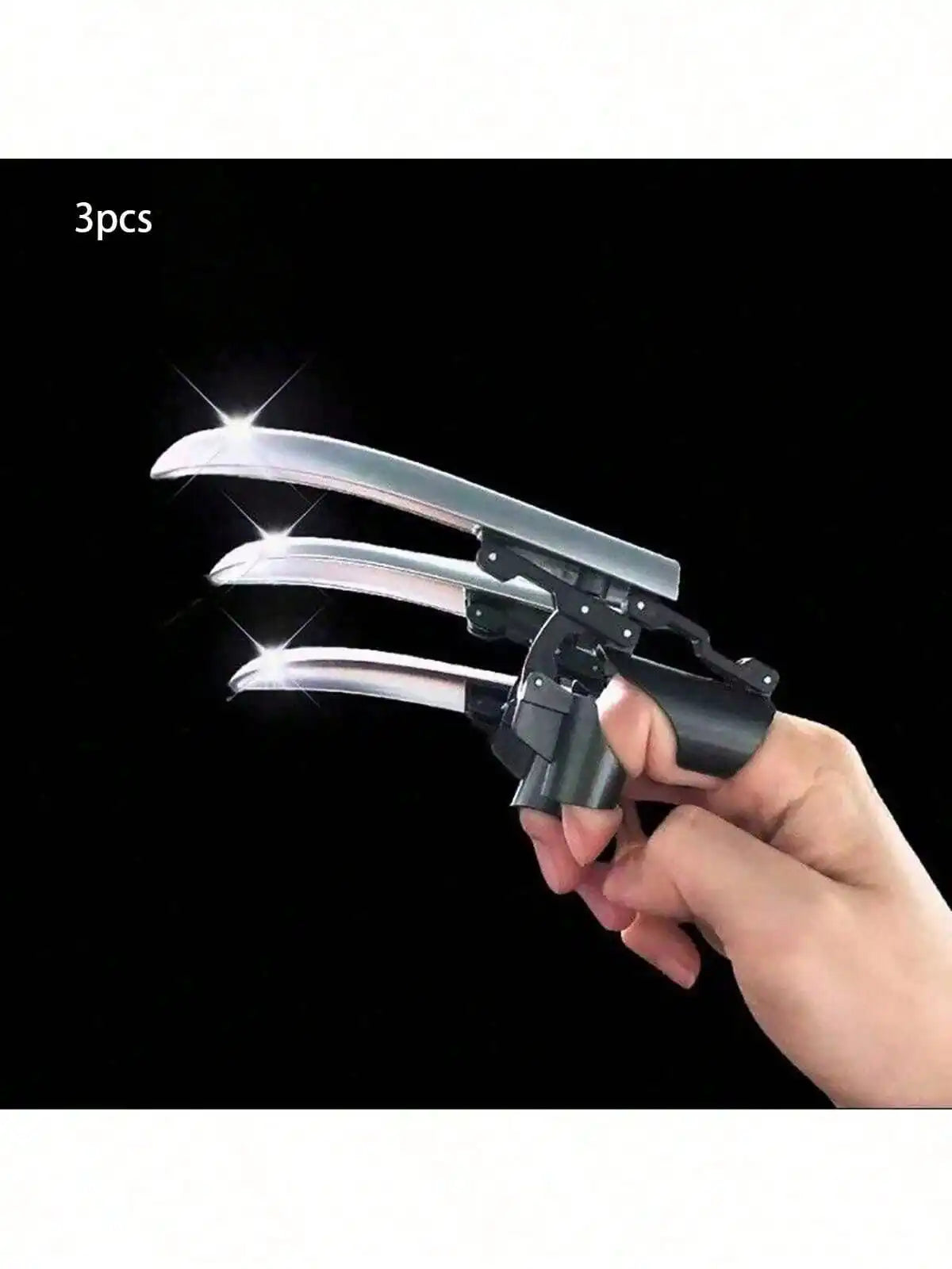 A hand holds a silver retractable mechanical wolf claw prop with flexible knuckles against a black background.