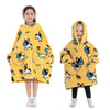 A young girl models a yellow cozy kids flannel hoodie sweater with a hood and animal print.