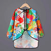 A colorful kids waterproof long-sleeve art smock and dining bib featuring paint splatter designs.
