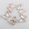 Gold-toned crystal butterfly charm beads arranged in a circular pattern for jewelry making