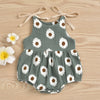 A gray cotton romper for a baby girl with a white daisy floral print, tied at the shoulders.