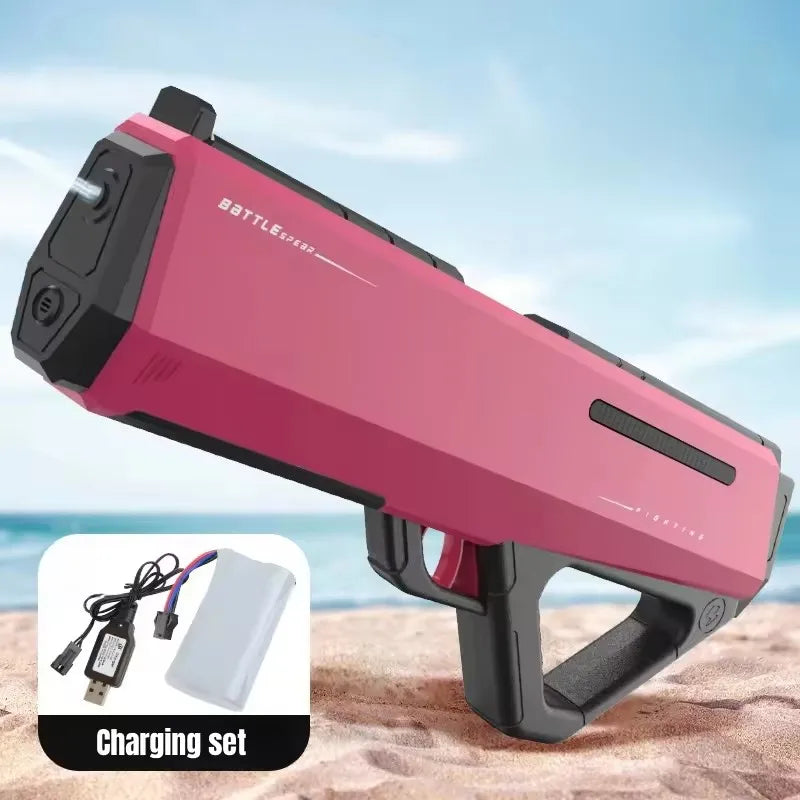 A pink high-pressure electric water gun is shown with its charging set on a sandy surface.