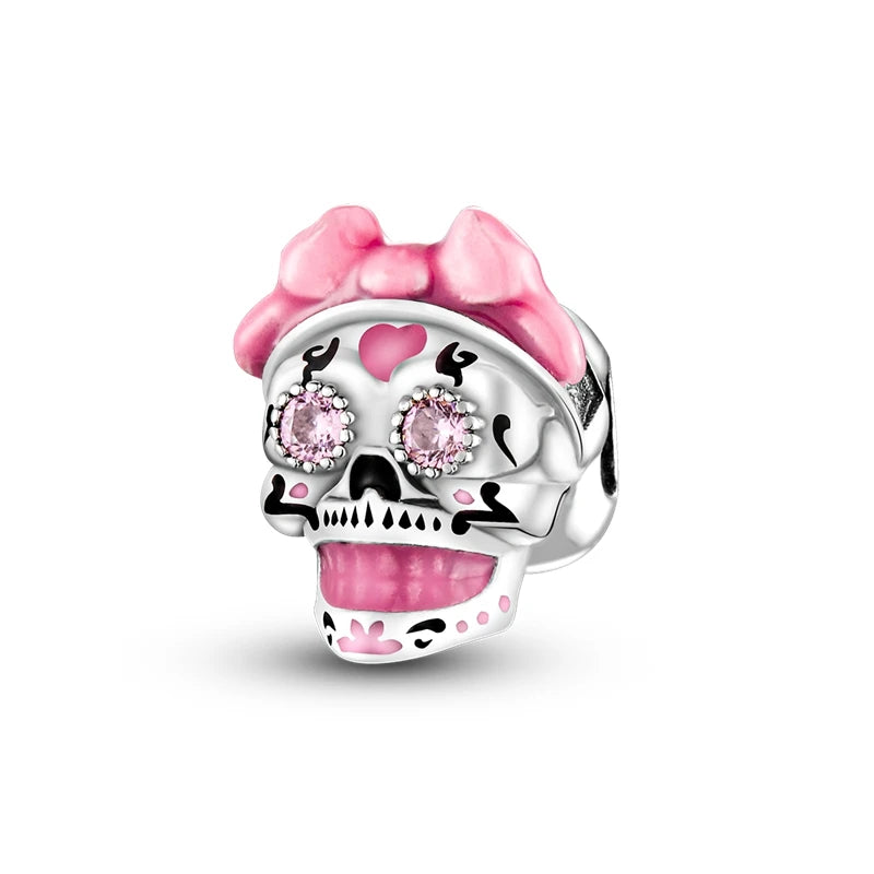 A silver skull charm bead featuring pink zirconia accents and a pink stylized cat head design.