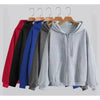 A display of various colored oversized zip-up hoodies hanging on wooden hangers.