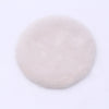 A round, fluffy, light pink or beige miniature carpet mat for dollhouse decor.