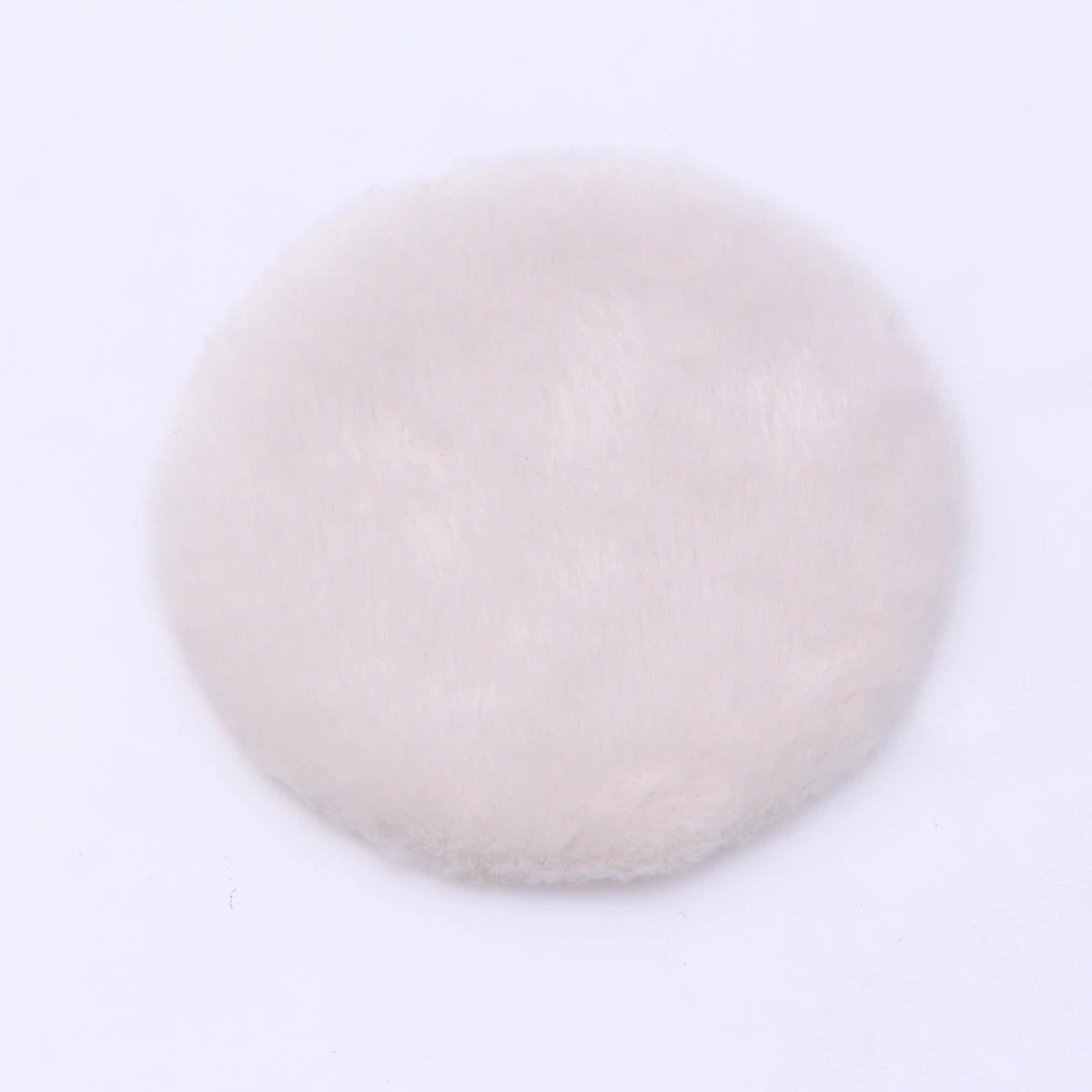 A round, fluffy, light pink or beige miniature carpet mat for dollhouse decor.