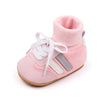 Pink ankle-hugging baby booties with white laces and anti-slip soles